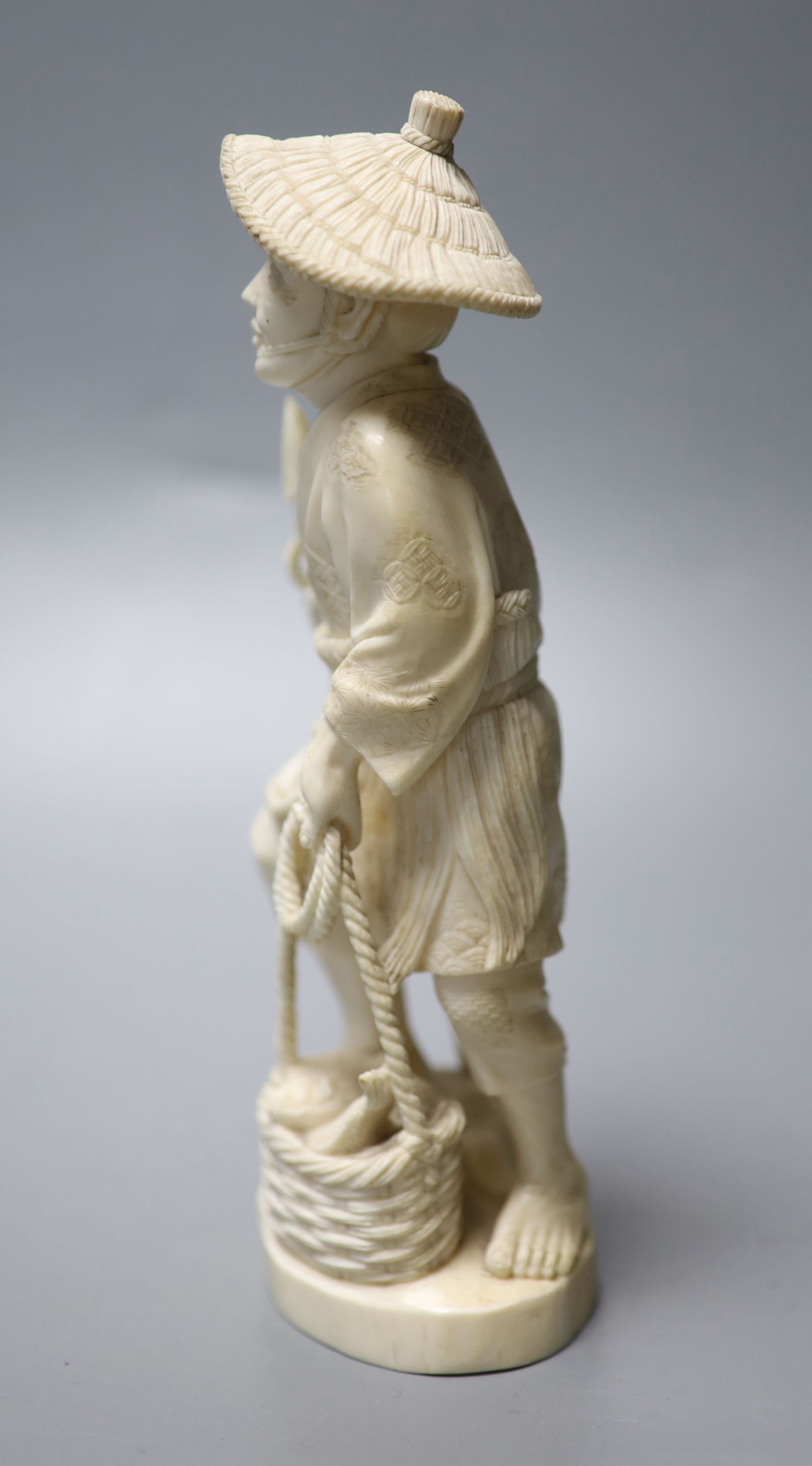 A Japanese Meiji period carved ivory figure of a fisherman, height 20cm